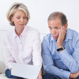 older foster parents looking and assessing information on lap top